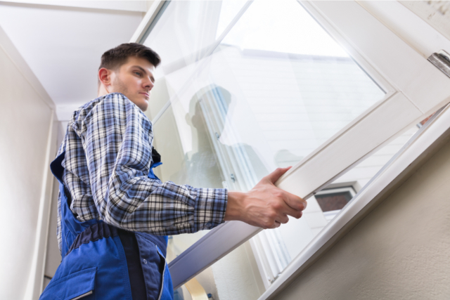 Male Repairman Installing Window